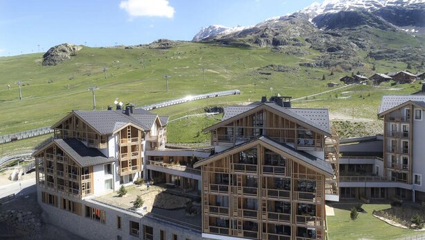 A modern building with large windows and a wooden facade, set against a mountainous backdrop. - Phoc16 Beautiful Apartment at the Foot of the Slopes, Very Pleasant in a new Residence (Huez)