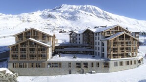 A snow-covered building with a mountain in the background. - Phoc16 Beautiful Apartment at the Foot of the Slopes, Very Pleasant in a new Residence (Huez)