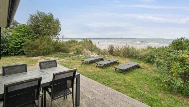 An outdoor deck with a view of the beach and ocean. - 4 Star Holiday Home in Nexo (Nexø)