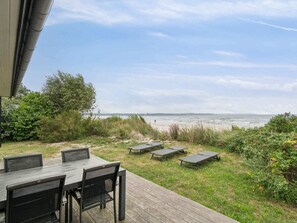 An outdoor deck with a view of the beach and ocean. - 4 Star Holiday Home in Nexo (Nexø)