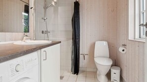 A modern bathroom with a wooden interior, a sink, a toilet, and a shower. - 4 Star Holiday Home in Nexo (Nexø)