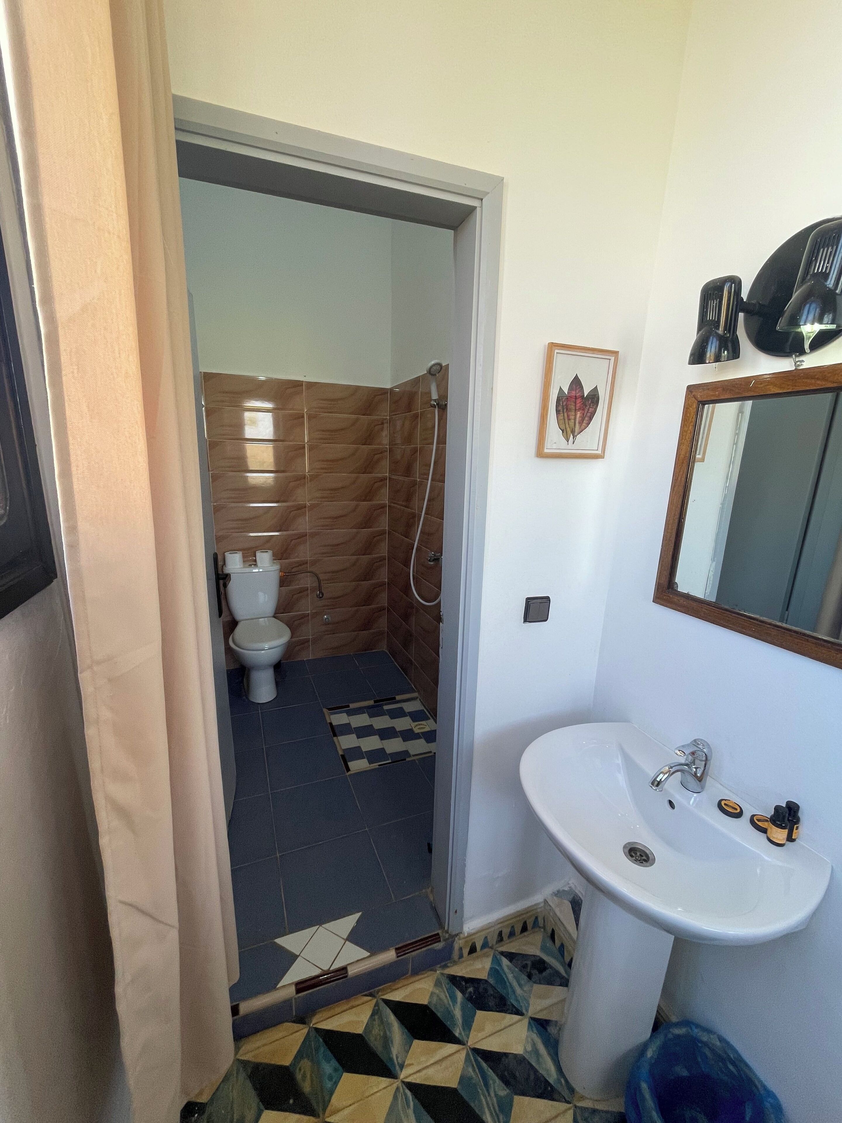 A bathroom with a shower, toilet, and sink.