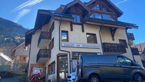 A chalet with a sign reading 'GO SPORT,' a wooden facade, and a mountain backdrop. - Apartment "Le Ressoutan" with Mountain View and Balcony (Saint-Colomban-des-Villards)