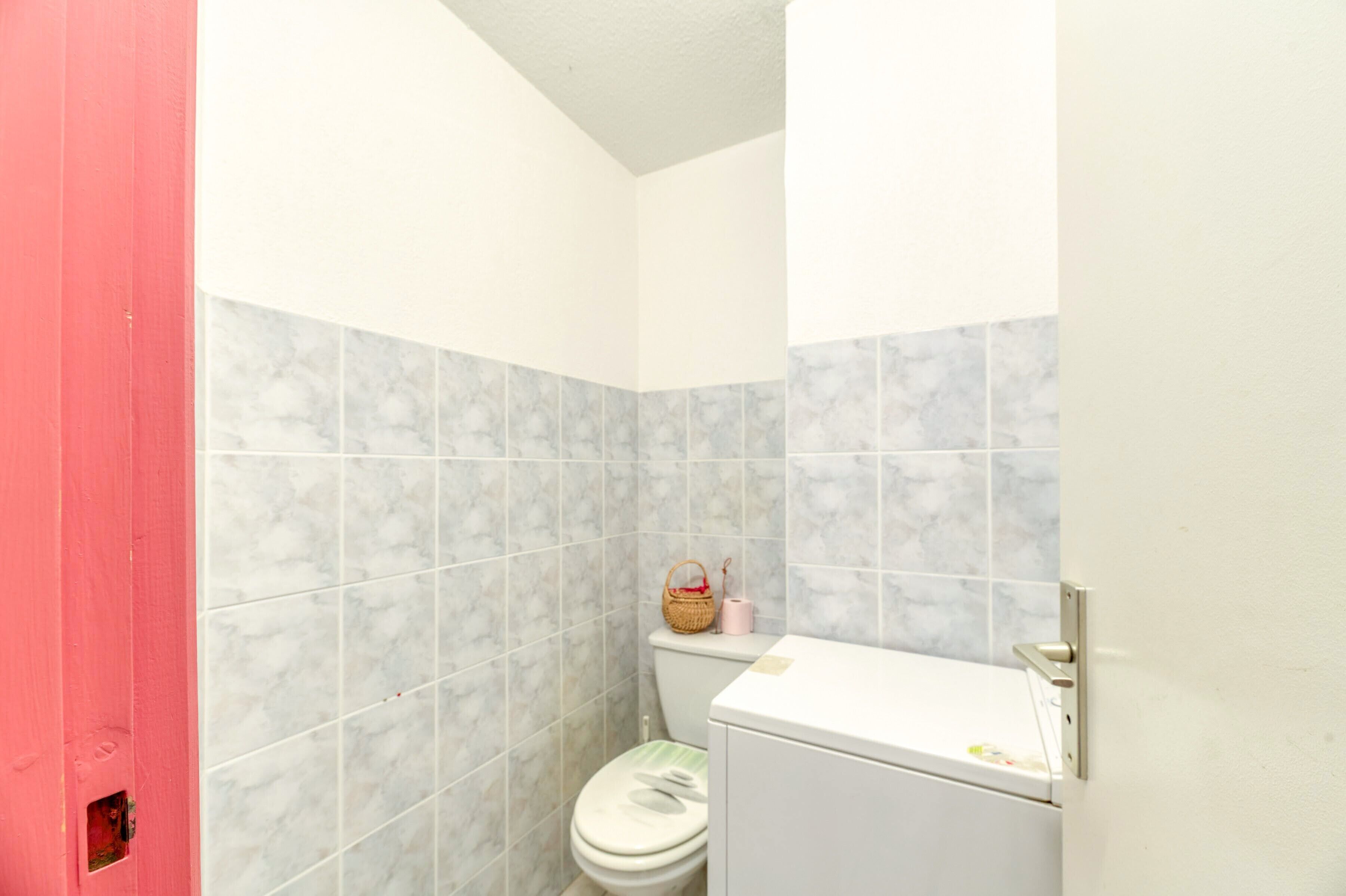 Un bagno piccolo con il water, un lavandino e uno specchio.