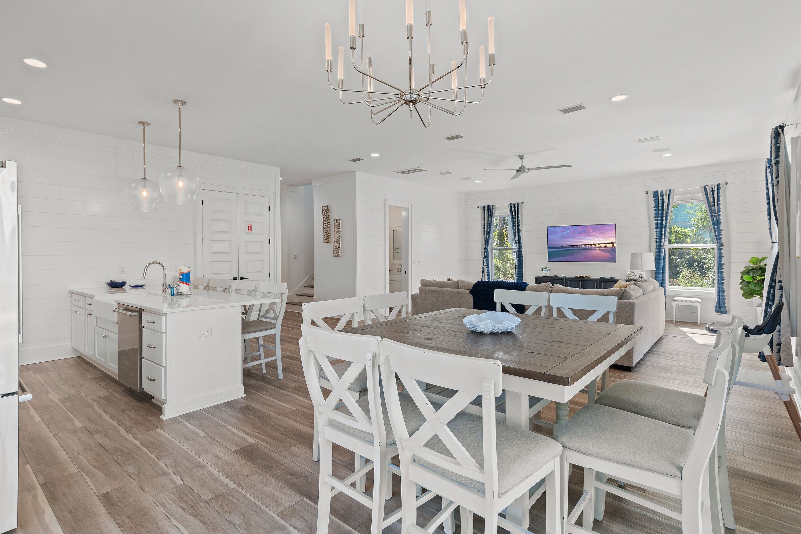A spacious kitchen with white cabinetry, a central island, and pendant lighting.
