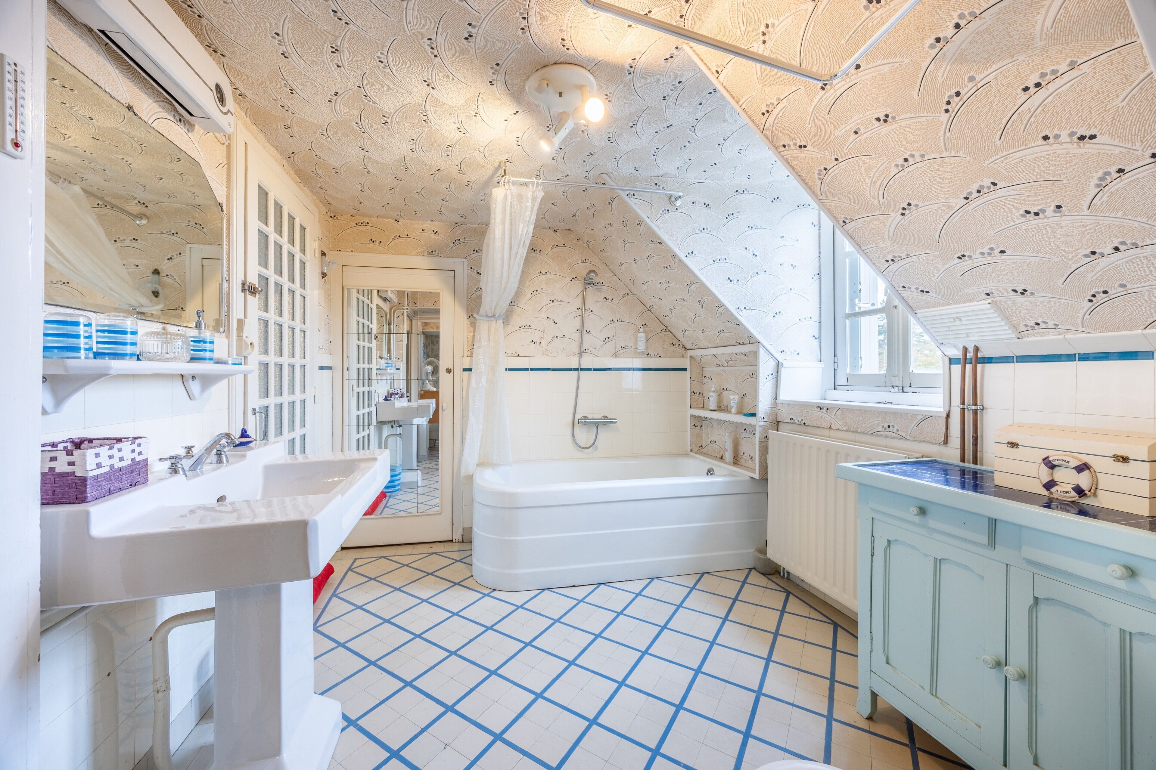 Une salle de bain équipée d’une baignoire, d’un lavabo et d’un meuble-lavabo avec un miroir.