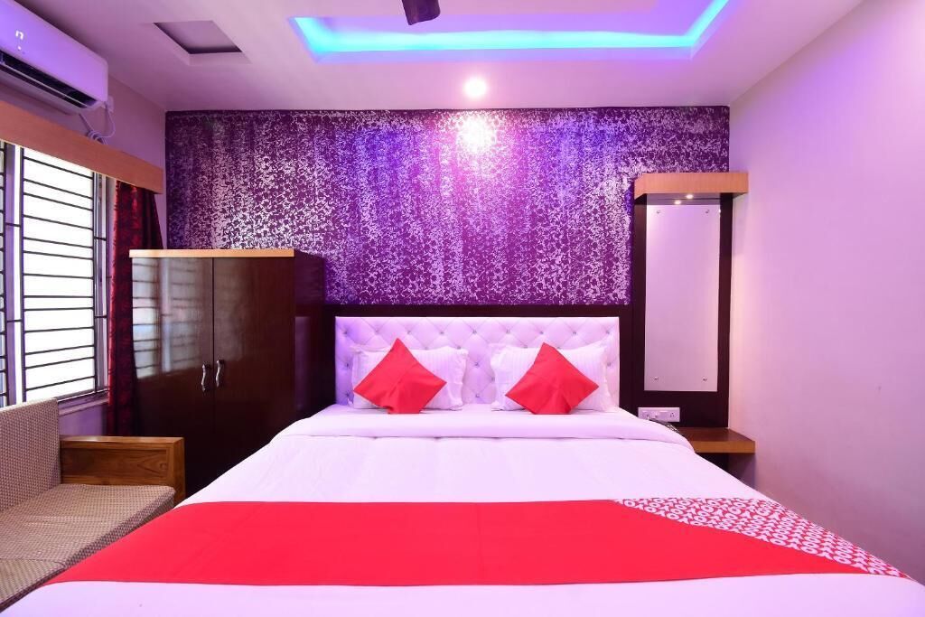 Une chambre d’hôtel avec un lit, une armoire, une table de chevet et une fenêtre avec des rideaux.