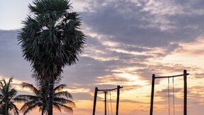 A beach with a swing set and palm trees. - Golden Sands - By The Bay Resorts (Bapatla)