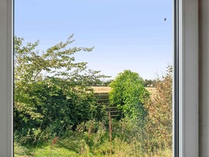 A view through a window of a rural landscape with greenery and a clear sky. - 5 Star Holiday Home in Thyholm (Thyholm)