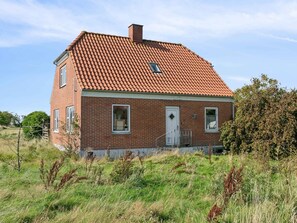 A single-story brick house with a red-tiled roof, a front door, and two windows. - 5 Star Holiday Home in Thyholm (Thyholm)