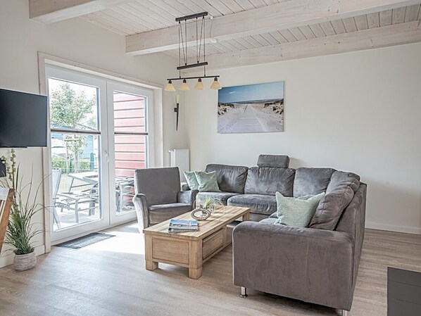A living room with a grey sofa, a wooden coffee table, and a painting on the wall.
