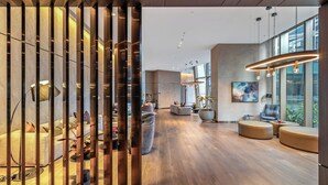 Un intérieur moderne avec un plancher en bois, un coin salon et une grande fenêtre.