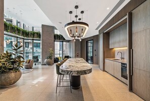 A modern interior with a marble bar, pendant lighting, and a view of the city.