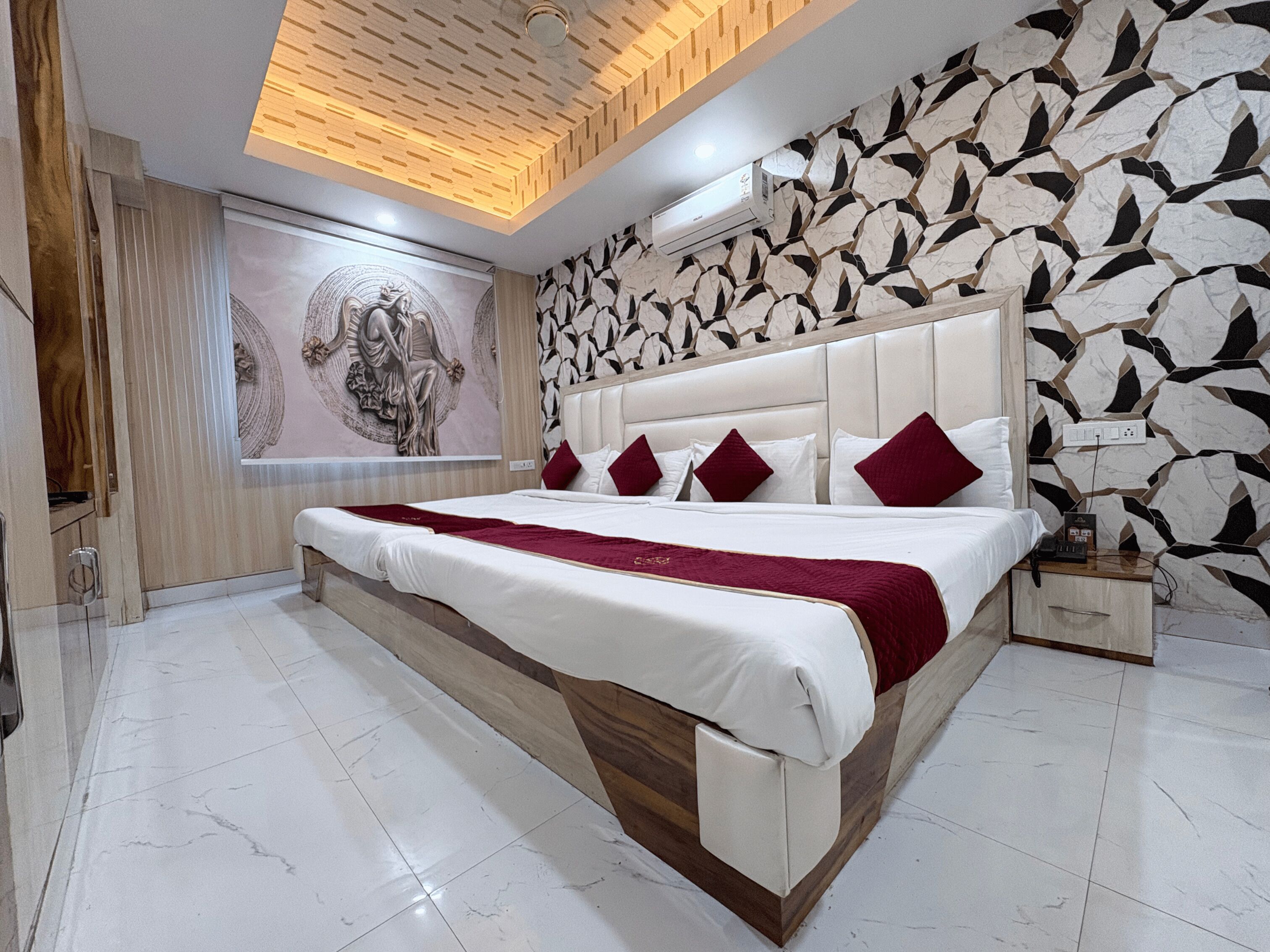 Ein modernes Schlafzimmer mit einem großen Bett, einer dekorativen Wandmalerei und einem strukturierten Wanddesign.