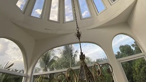 A circular room with multiple skylights and a chandelier.