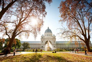 A large building with a dome and a fountain in front, surrounded by trees and people. - 2 bed Apartment in Trendy Collingwood (Melbourne)