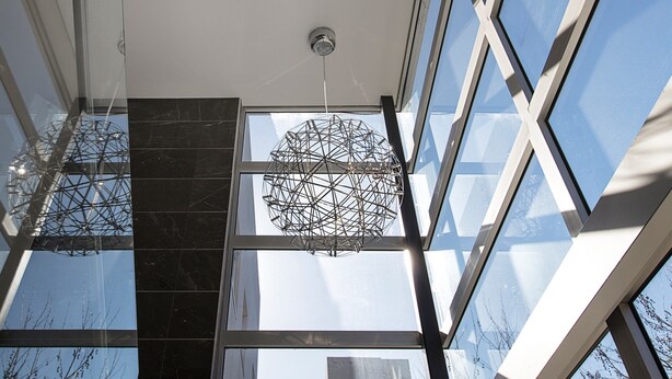 A modern interior with large windows, a geometric ceiling light, and a visible skylight. - Professional Living Minutes From the City (Sydney)