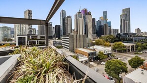 A cityscape with modern high-rise buildings, a mix of residential and commercial structures, and a clear blue sky. - City View Haven in South Melbourne (Melbourne)