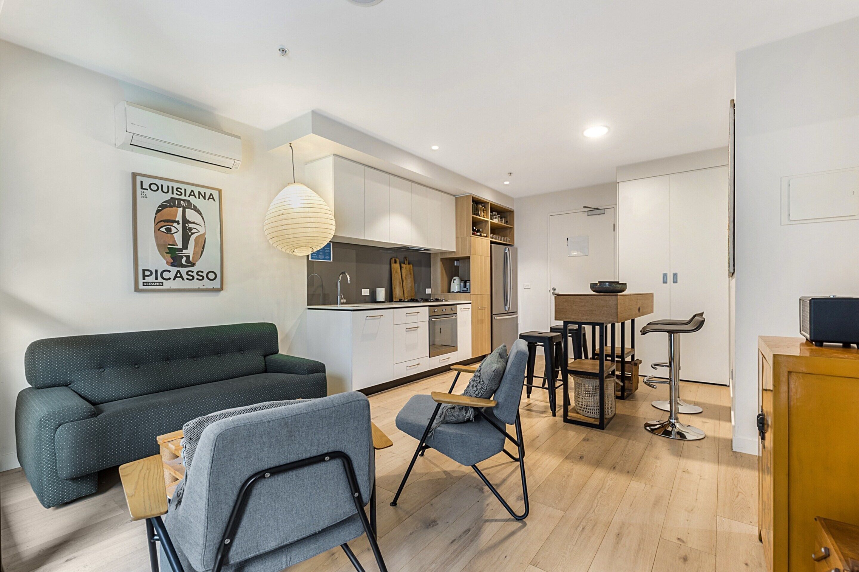 A modern apartment with a living room, kitchen, and dining area.