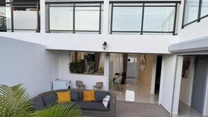 Un interior moderno con un sofá, sillas y una zona de comedor.