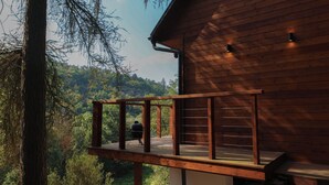 A wooden cabin with a deck overlooking a forested area. - Chata Cedrus (Hradištko)