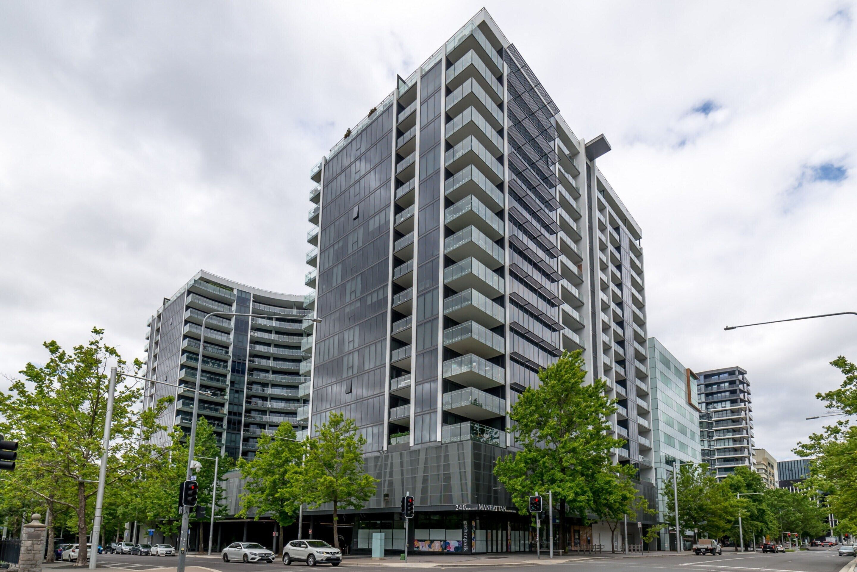 A modern high-rise building with multiple balconies and a glass facade.
