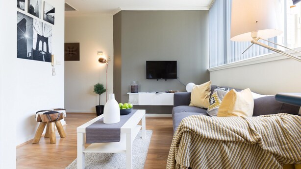A modern living room with a sofa, coffee table, and a television.