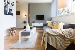 Una sala de estar moderna con un sofá, una mesa de centro y un televisor.