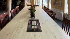 A long dining table with chairs, a ceiling mural, and large windows. - Home Le Soft (Vic-sur-Cère)