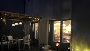 A snow-covered outdoor area with a seating area and a building entrance. - Home Le Soft (Vic-sur-Cère)
