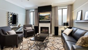 A modern living room with a fireplace, leather sofas, a coffee table, and a television. - Family Retreat In Top Blue Mountains Location (Katoomba)