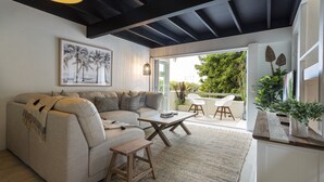 Ein modernes Wohnzimmer mit Sofa, Couchtisch und Blick ins Freie.