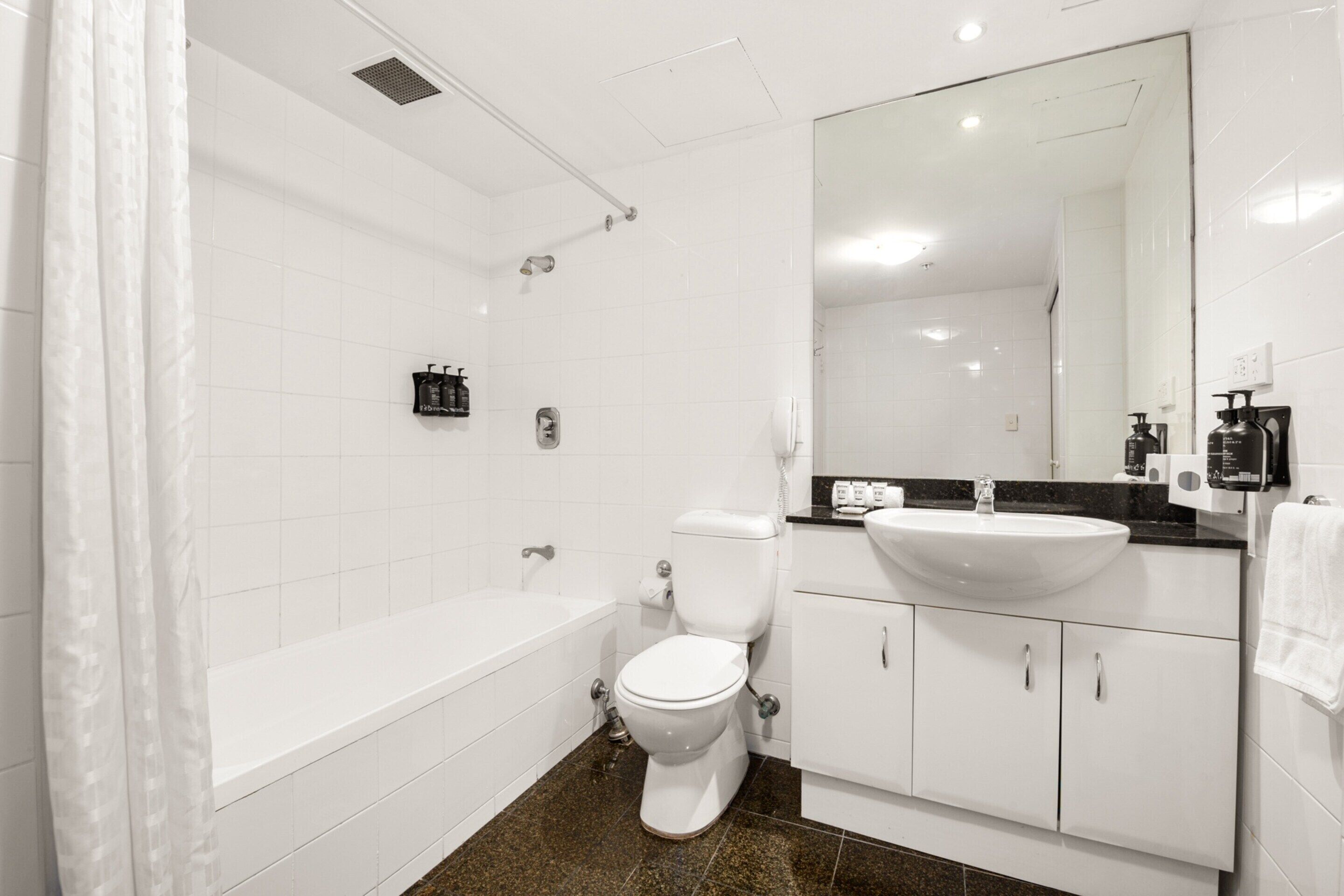 A modern bathroom with a bathtub, toilet, and sink.