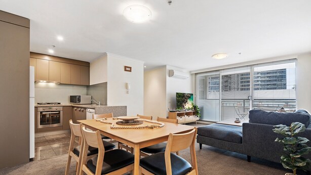 A modern apartment with a dining area, kitchen, living room, and large windows. - Gorgeous 3-bed Apartment Near Flagstaff Gardens (Melbourne)