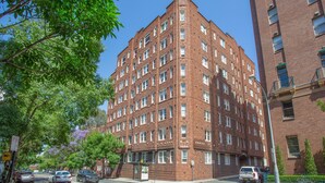 A red brick building with multiple windows and a corner entrance. - Stylish Studio Near Kings Cross Train Station (Sydney)