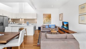 A modern apartment with a kitchen, dining area, and living room. - 2-bed Apartment With Parking & Balcony Near Trains (Melbourne)