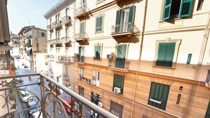 Un edificio a più piani con balconi, una strada sottostante e cielo sereno.