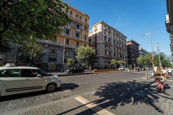 A street scene with buildings, a pedestrian crossing, and a white car.