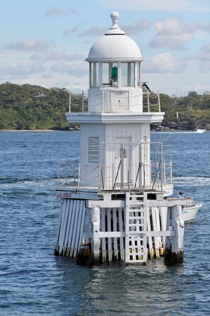A white lighthouse on a small island in the water. - Unit With Balcony, Backyard and Parking Near Shops (Sydney)