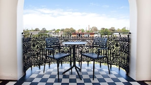 A balcony with a checkered floor, two chairs, and a table. - Charming Studio With Balcony in Inner-city Glebe (Sydney)