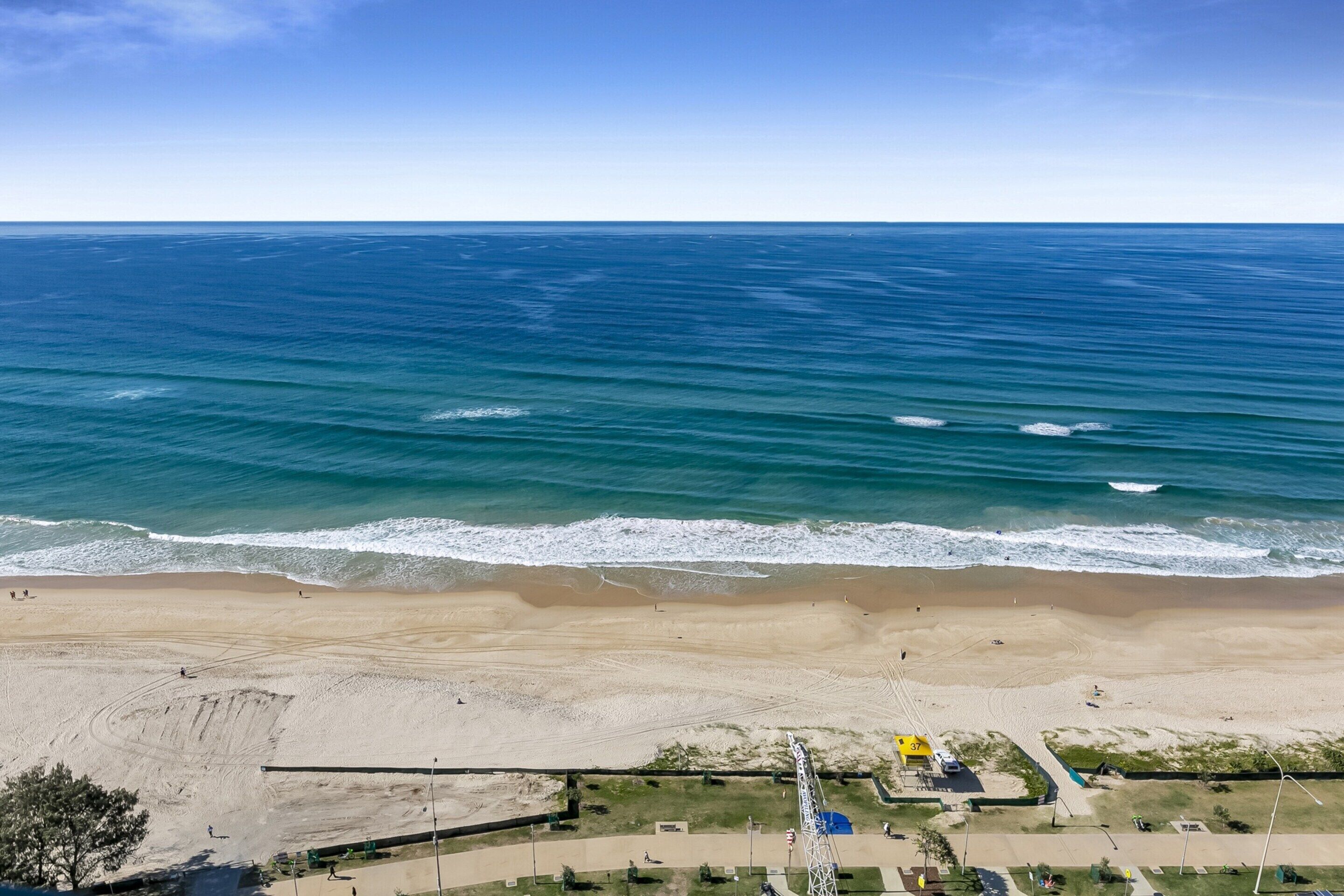 A beach with a clear view of the ocean and a sandy shore.