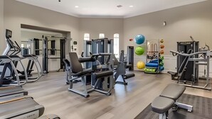Academia com esteiras, aparelhos de musculação e bolas de exercício.