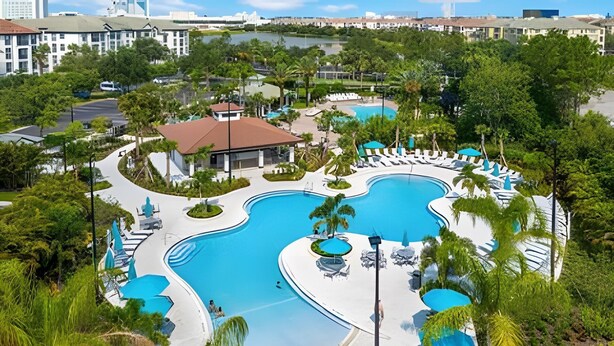 Resort com várias piscinas, áreas de descanso e vegetação exuberante.