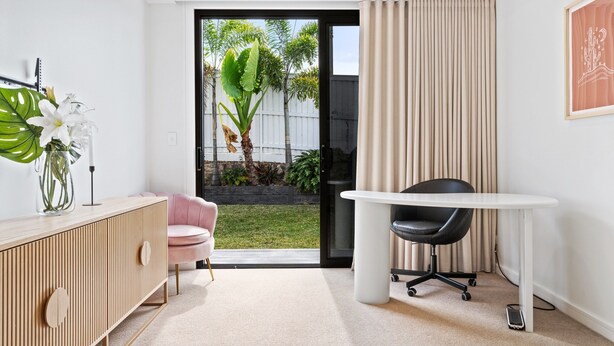 A modern office space with a desk, chair, and a potted plant. - Deluxe 4-bed Home With Pool & Fire Pit (Brisbane)