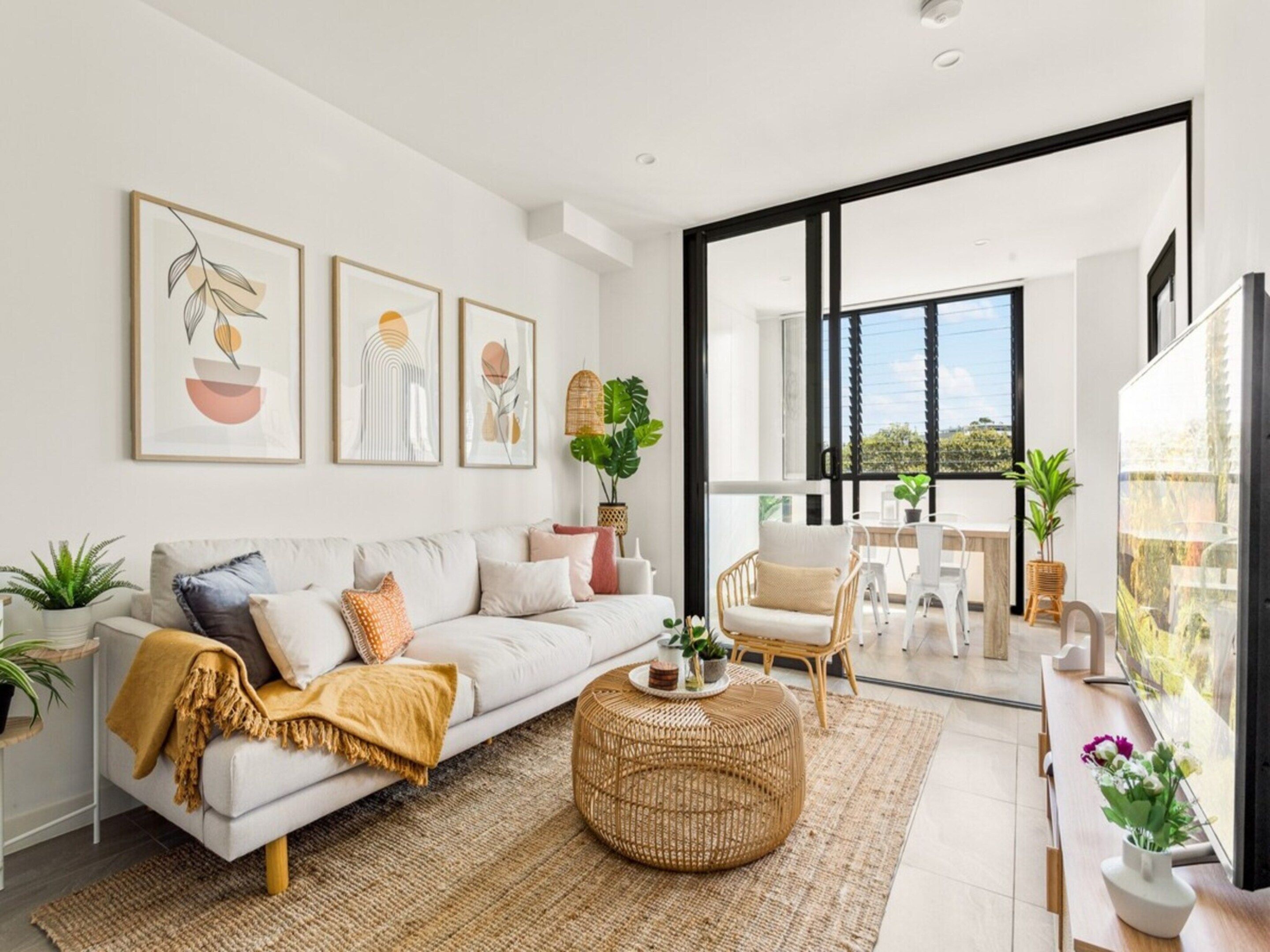 A modern living room with a sofa, coffee table, and artwork on the wall.