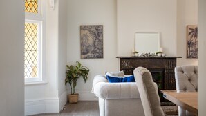 Een kamer met een open haard, een eettafel en een gezellige zithoek.