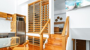 Una cucina moderna con pavimento in legno, un tavolo da pranzo in vetro e un forno a microonde integrato.