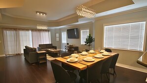 Un salon spacieux avec un coin repas aménagé pour prendre un repas.