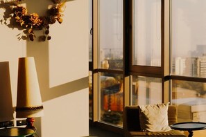 A room with a large window, a sofa, and a lamp. - WN Hotel (Sofia)