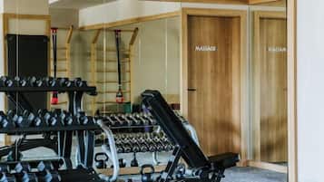 A gym with exercise equipment, a mirror, and a massage room.